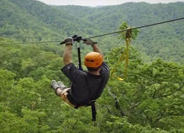 an adventure seeker enjoying a zipline setup built by Oxo